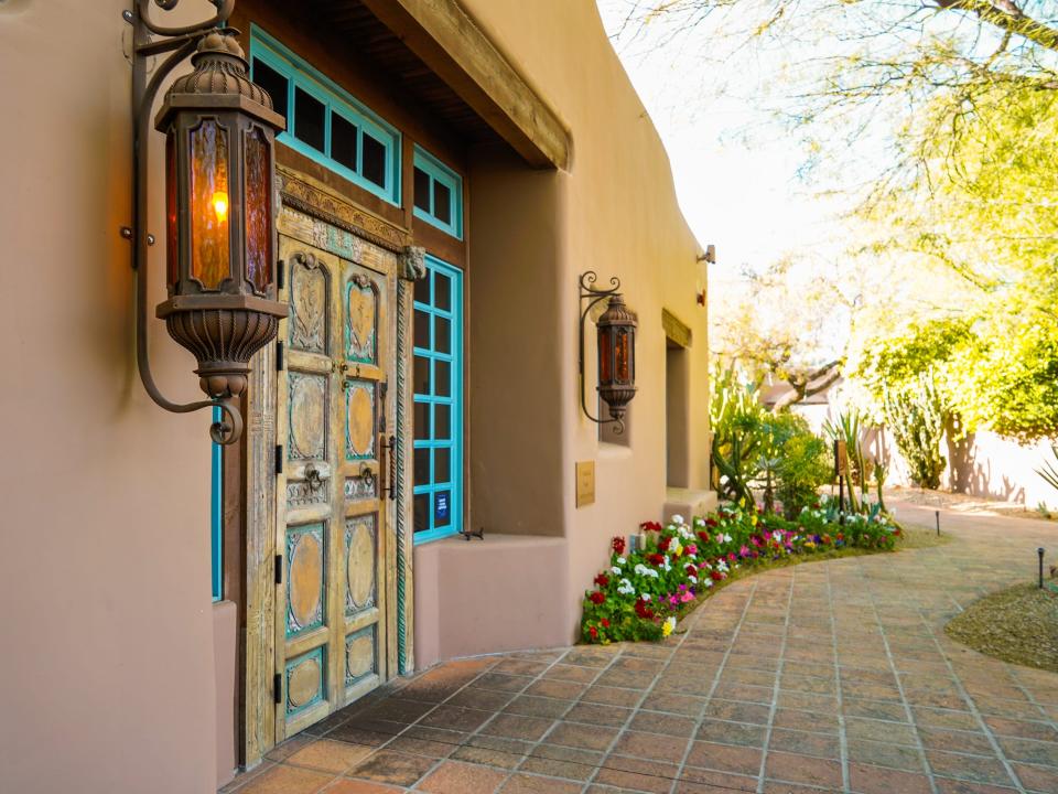 An adobe building on the left and a garden path on the right at Hermosa Inn