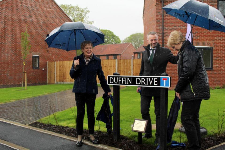 Eastern Daily Press: Pam Duffin, Saffron Housing Trust's James Francis and Barry Duffin's daughter Kate unveiling Duffin Drive in Wymondham