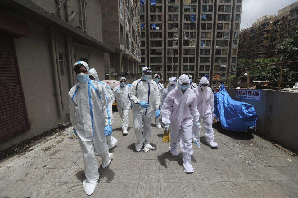 Health workers walks back after conducting a free medical checkup at residential building in Mumbai, India, Thursday, July 2, 2020. Indian Prime Minister Narendra Modi said in a live address Tuesday that the country's coronavirus death rate is under control, but that the country is at a "critical juncture." But since the lockdown was lifted, the caseload has shot up, making India the world's fourth-worst affected country. (AP Photo/Rafiq Maqbool)