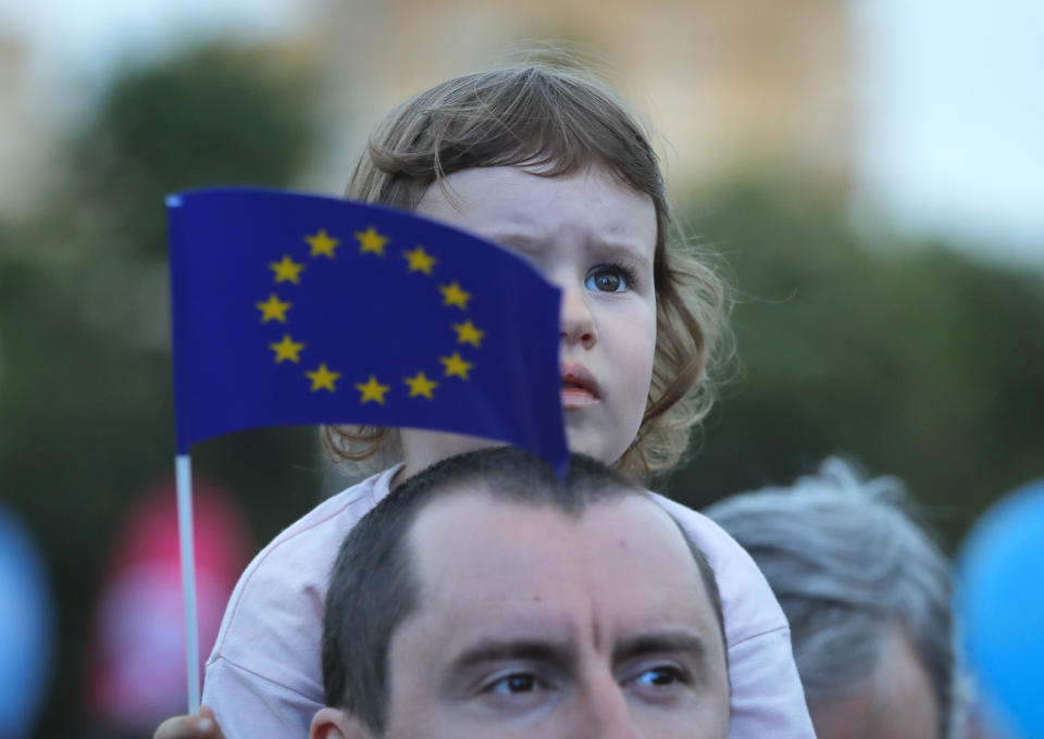 A child holds the European Union flag during a pro-Europe event dubbed "All for Europe" outside the government headquarters in Bucharest, Romania, Sunday, May 19, 2019. Thousands gathered to express their support for Europe, calling for a high attendance at the upcoming European Parliament elections that will take place on May 26. (AP Photo/Vadim Ghirda)