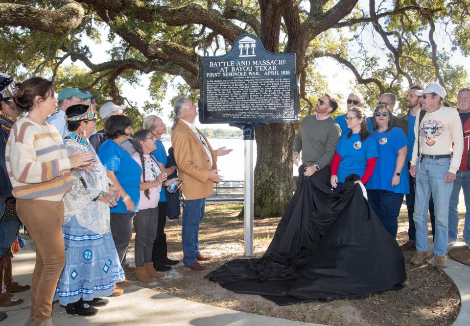 Dan Helms, chief of the Santa Rosa Band of Lower Muscogee, center left, and Pensacola Mayor D.C. Reeves unveil an historic marker commemorating the Battle and Massacre at Bayou Texar at Bayview Park in Pensacola on Thursday, Nov. 2, 2023.