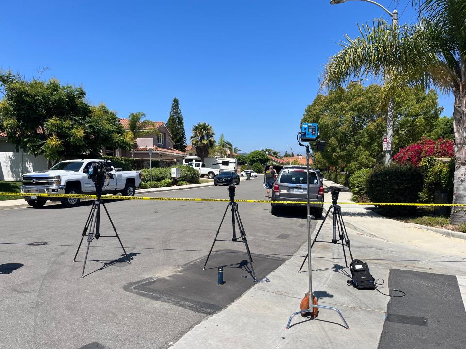 News media cameras stand outside yellow police tape on a Camarillo street as Orange County Sheriff's officials search a home on Thursday connected to a shooting at a popular biker bar Wednesday night.