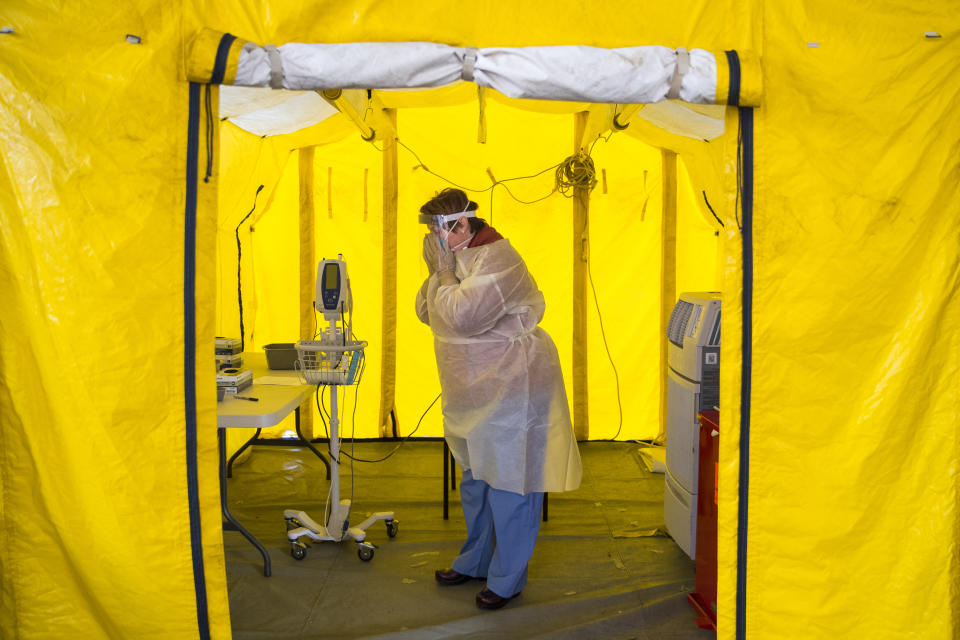 NEWTON, MA - MARCH, 16: Nurse practitioner Amy Israelian puts on protective gear in a tent in the parking lot of the Newton-Wellesley Hospital before testing a possible coronavirus patient in Newton, MA on March 16, 2020. (Photo by Adam Glanzman/For The Washington Post via Getty Images)