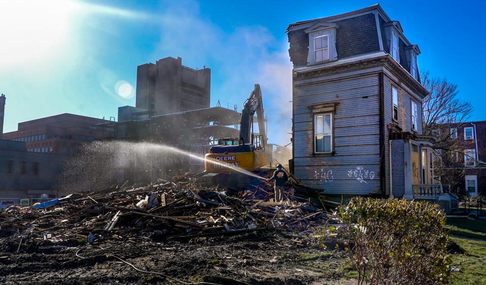 Crews demolish three homes on Angell Street in Providence that were built in the late 1800s. They were part of the College Hill Historic District.