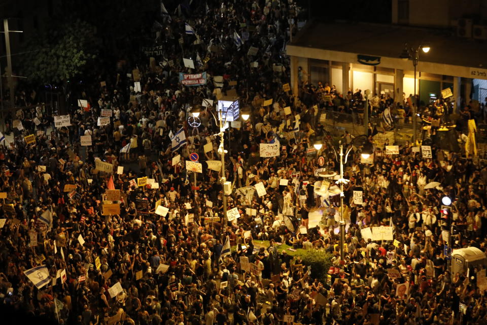 Thousands of demonstrators chant slogans and hold signs during a protest against Israel's Prime Minister Benjamin Netanyahu outside his residence in Jerusalem, Saturday, July 25, 2020. Protesters demanded that the embattled leader resign as he faces a trial on corruption charges and grapples with a deepening coronavirus crisis. (AP Photo/Ariel Schalit)