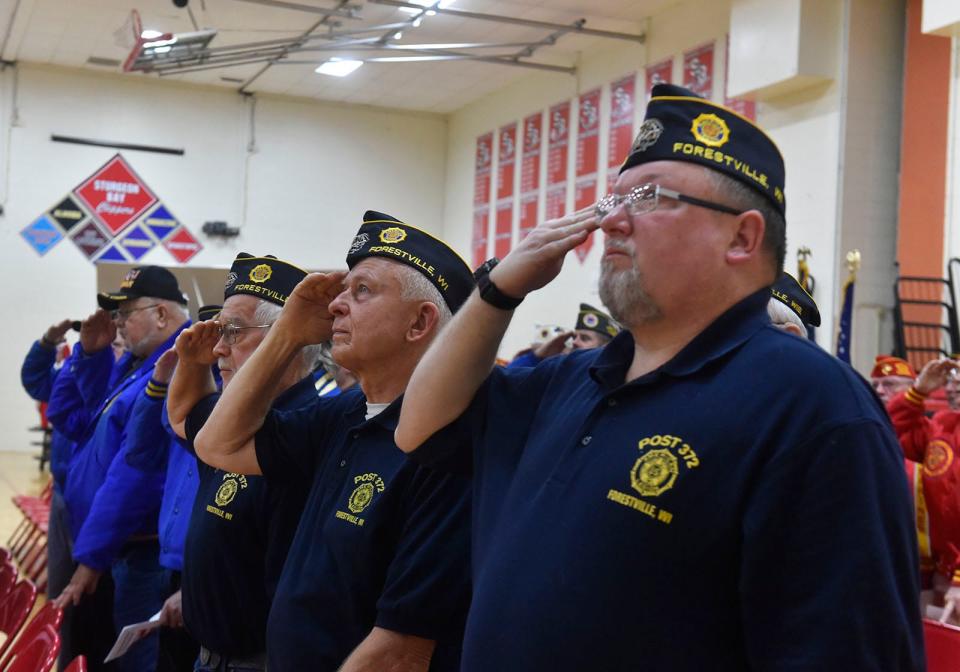 Participants salute during a Veterans Day ceremony in 2018 at Sturgeon Bay High School.