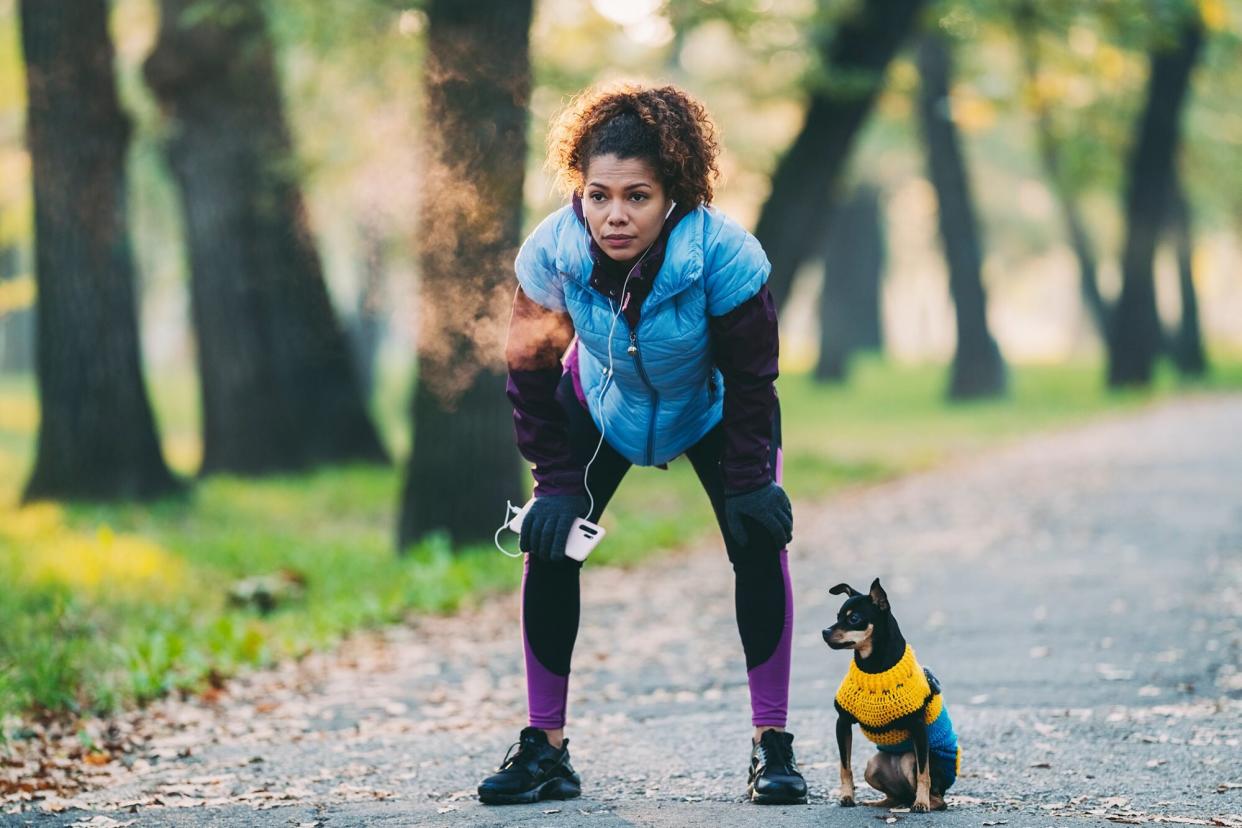 woman taking a breath after a run with her dog