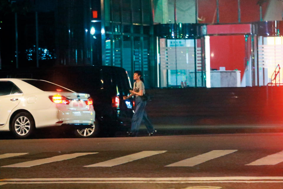 11/8，23：03魏如萱邊喝水邊在路邊耐心等待多元計程車到來，最後搭車回家。