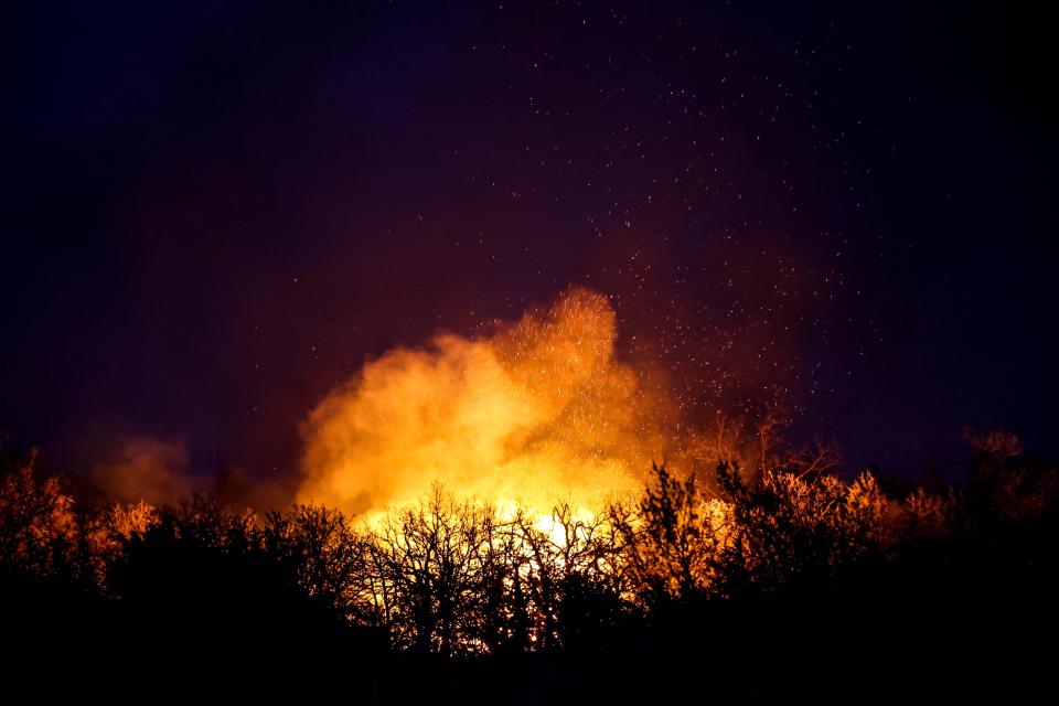 A wildfire rages in Logan County near Guthrie, Okla., on Friday, March 31, 2023.