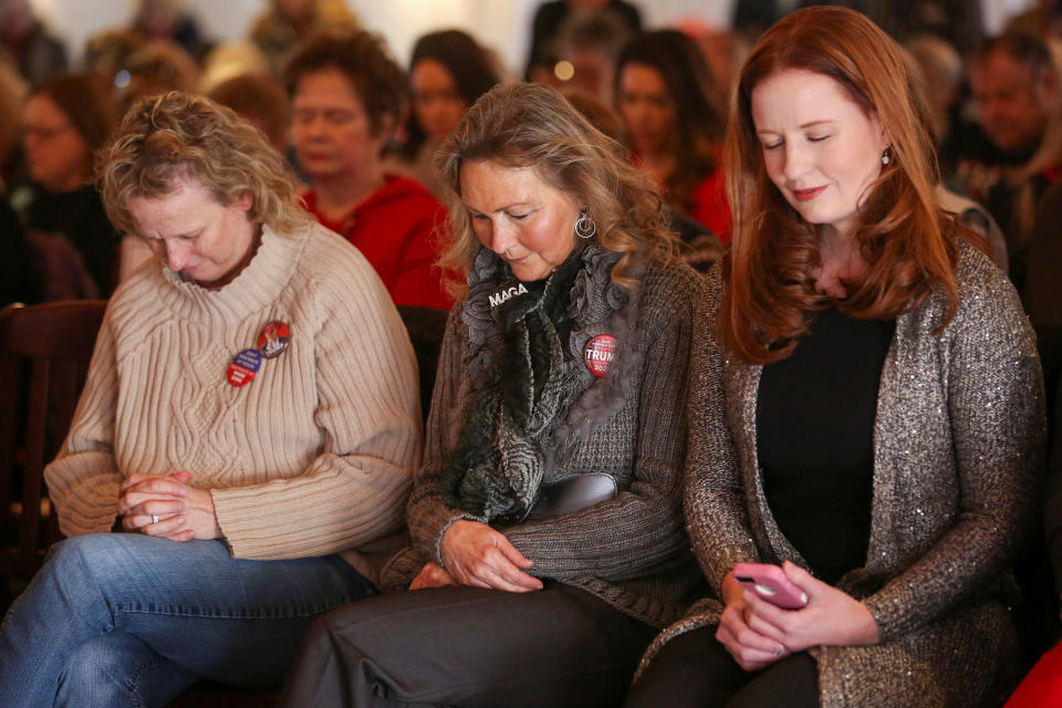 Supporters bow their heads in prayer at a Women for Trump bus tour stop in Sioux City, Iowa, on Jan. 16. (Photo: Brenna Norman / Reuters)