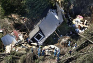 <p>Police search missing persons around houses destroyed by a landslide after an earthquake in Atsuma town, Hokkaido, northern Japan, Thursday, September 6, 2018. A powerful earthquake rocked Japan’s northernmost main island of Hokkaido early Thursday, triggering landslides that crushed homes, knocking out power across the island, and forcing a nuclear power plant to switch to a backup generator. (Kyodo News via AP) </p>