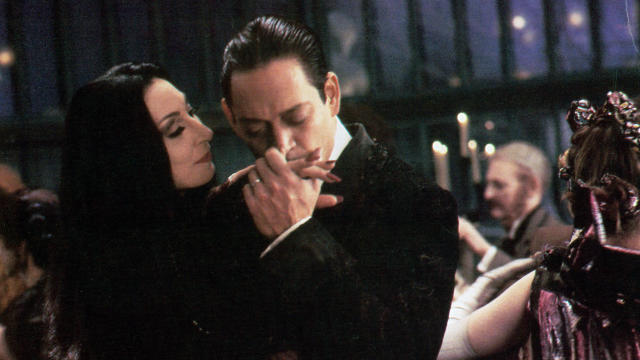 Anjelica Huston is kissed by Raul Julia in a scene from the film 'The Addams Family', 1991. (Photo by Orion/Getty Images)