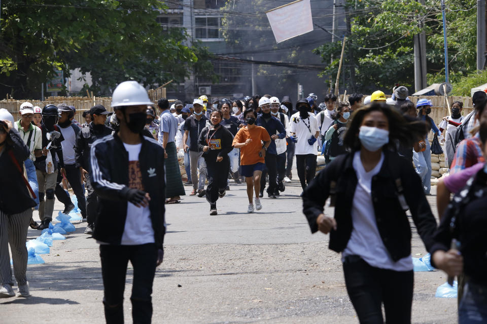 Anti-coup protesters abandon their makeshift barricade and run as policemen charge in Yangon, Myanmar, Friday, March 19, 2021. Authorities in Myanmar arrested a spokesman for ousted leader Aung San Suu Kyi’s political party as they intensify efforts to choke off the spread of information about growing protests against last month’s military takeover. (AP Photos)