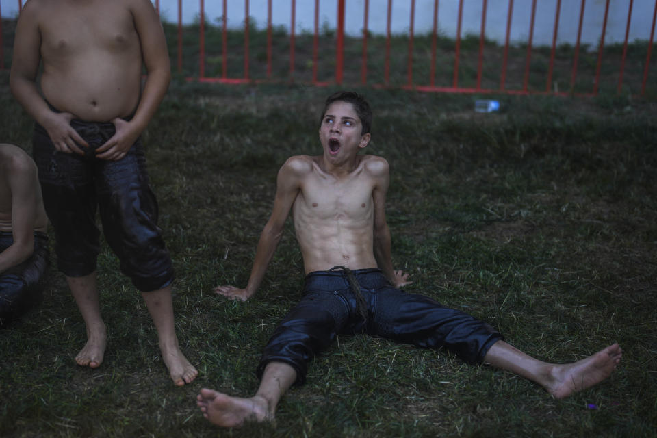 A young wrestler waits for his turn to wrestle during the 663rd annual Historic Kirkpinar Oil Wrestling championship, in Edirne, northwestern Turkey, Saturday, July 6, 2024. Wrestlers take part in this "sudden death"-style traditional competition wearing only a pair of leather trousers and a good slick of olive oil. The festival is part of UNESCO's List of Intangible Cultural Heritages. (AP Photo/Khalil Hamra)