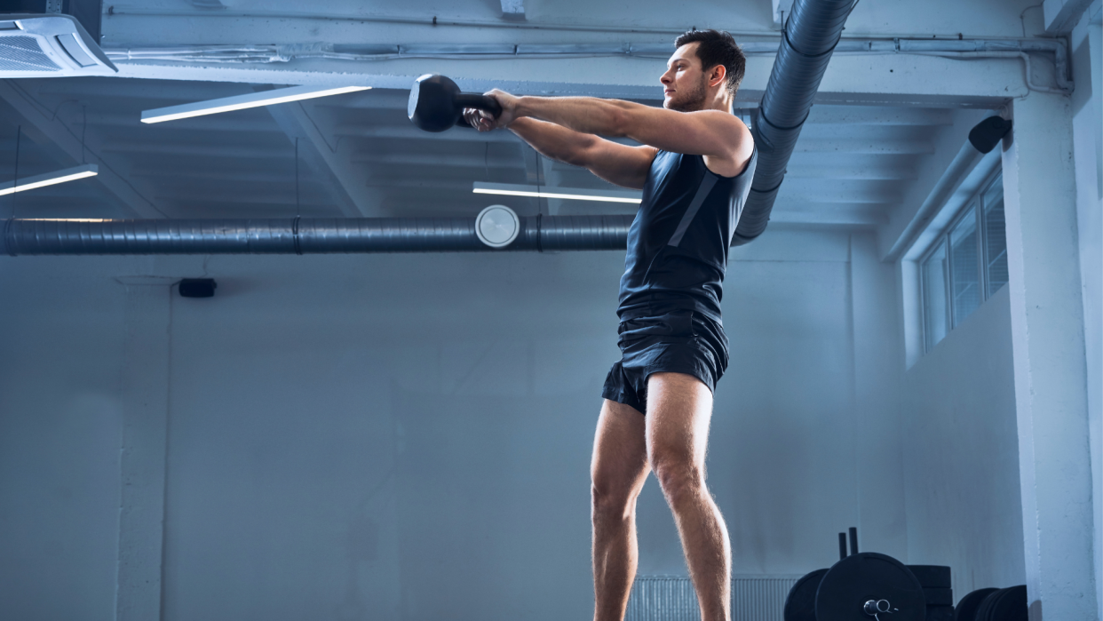  Man performing a kettlebell swing. 