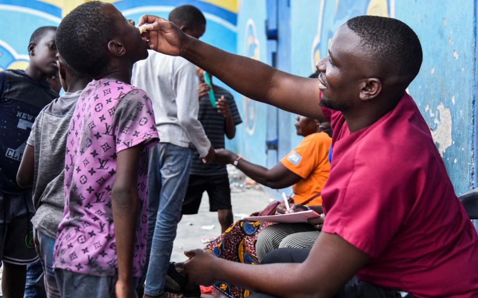 A man administers the cholera vaccine to a child at a temporary cholera treatment centre which has been set up to deal with the latest deadly cholera outbreak, at the Heroes National Stadium in Lusaka, Zambia