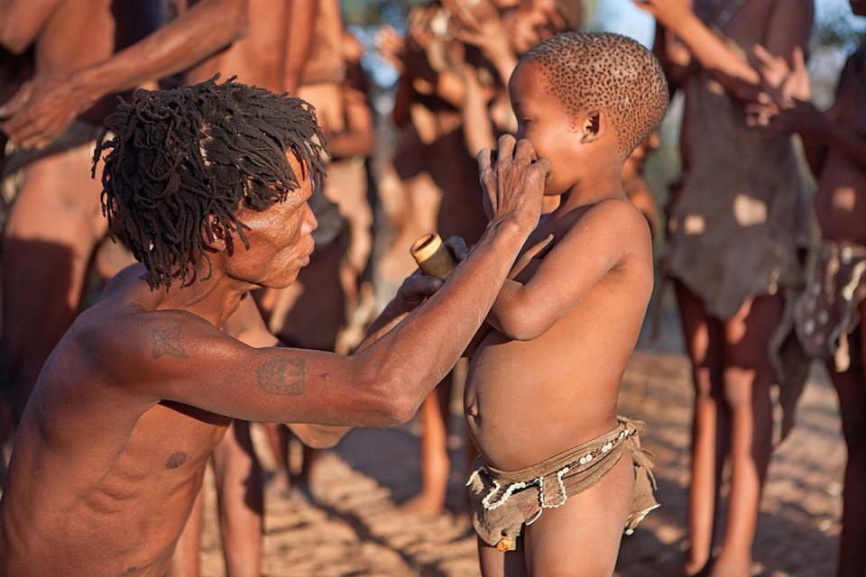 A San elder paints a child’s face. Hoberman/Universal Images Group via Getty Images