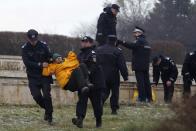 A Greenpeace activist is detained by gendarmes, after the group protested against a Canadian company's plan to set up Europe's biggest open-cast gold mine in Romania by digging up the front yard of Romania's parliament, in Bucharest December 9, 2013. A special Romanian parliament commission overwhelmingly rejected a draft bill that would have allowed Canada's Gabriel Resources to set up Europe's biggest open-cast gold mine in the small Carpathian town of Rosia Montana last month. However, parliament plans to revise a mining law that could open way for the project. REUTERS/Bogdan Cristel (ROMANIA - Tags: ENVIRONMENT SOCIETY CIVIL UNREST BUSINESS)