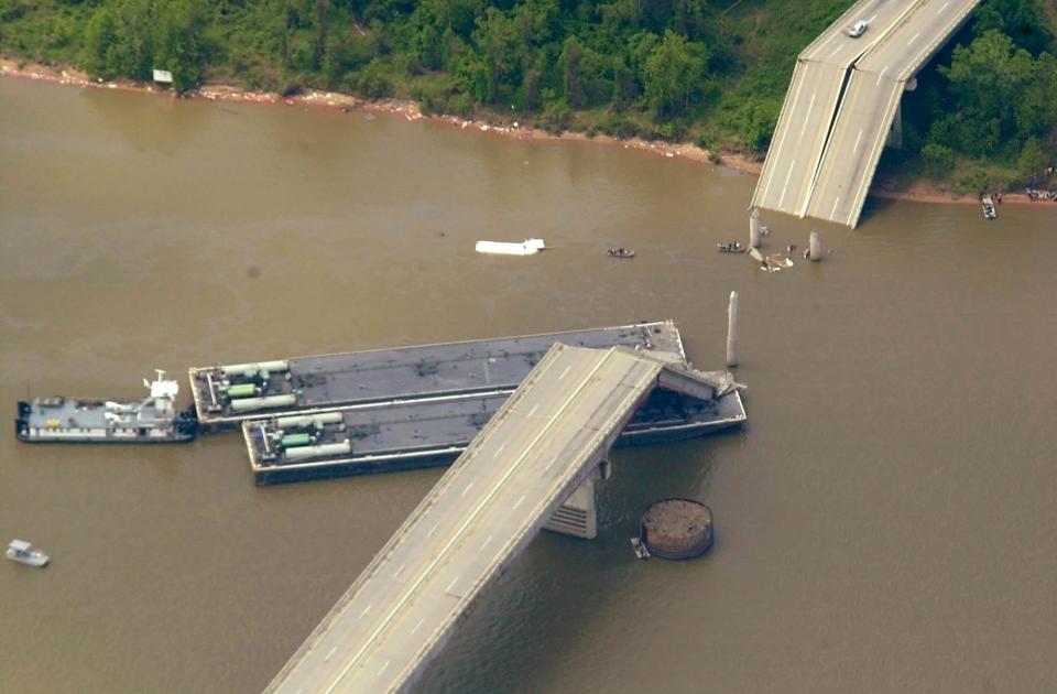 A piece of the I-40 bridge over the Arkansas River near Webbers Falls, Okla., rests on a barge that collided with the bridge Sunday morning, May 26, 2002. This aerial view is looking west.