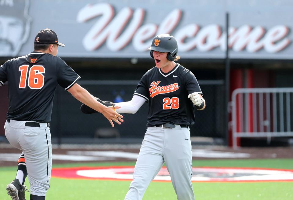 Ty Sowers, 28, of North Canton Hoover is "welcomed" back to the dugout by Will Paz, 16, during a Division I district semifinal baseball game against Dover at Thurman Munson Memorial Stadium in Canton on Tuesday, May 24, 2022.