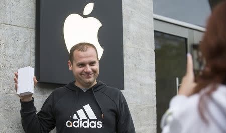 A man poses for a photo after buying the newly released iPhone 6 at the Apple store in Berlin September 19, 2014. REUTERS/Hannibal