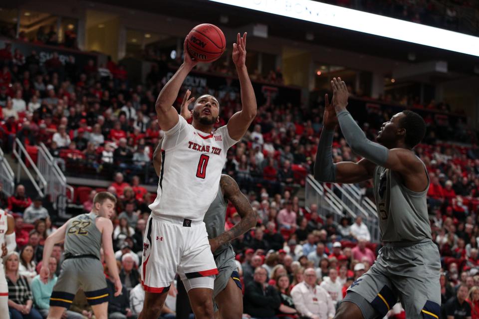 Texas Tech's Kevin Obanor (0) shoots against West Virginia's Dimon Carrigan (5) during the first half of a Big 12 Conference game Saturday at United Supermarkets Arena.