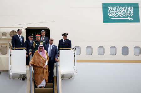 Saudi Arabia's King Salman stands on an escalator as he arrives at Halim Perdanakusuma airport in Jakarta, Indonesia March 1, 2017. REUTERS/Beawiharta