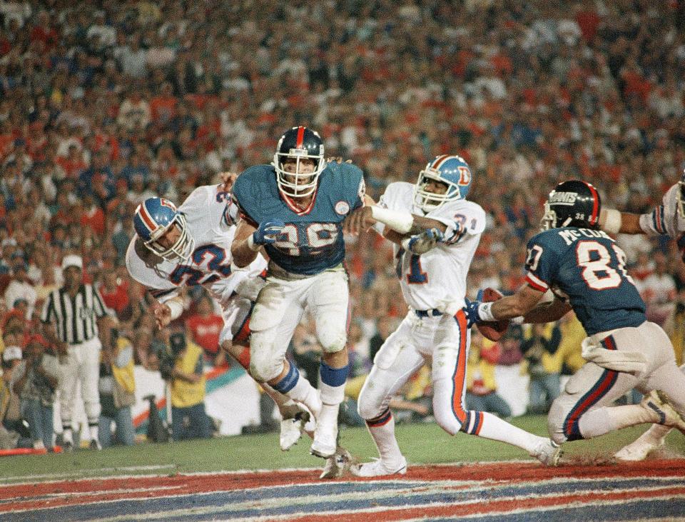 New York Giants Phil McConkey dives for the ball for a touchdown after it bounced off Mark Bavaro (left) in the fourth quarter of Super BowlXXI, Jan. 25, 1987, in Pasadena. Center is Broncos cornerback Mike Harden (31).