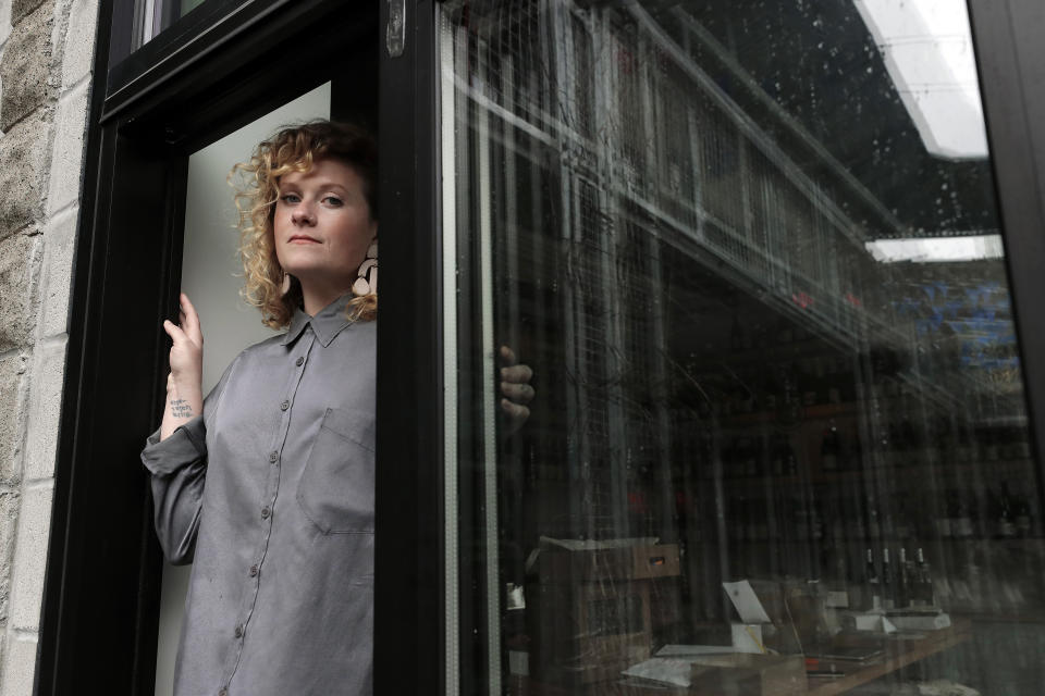 Lauren Friel, owner of Rebel Rebel Wine Bar, in Somerville, Mass., stands for a portrait at the wine bar, Thursday, April 2, 2020. An Associated Press review of the small business aid passed by Congress as part of its coronavirus stimulus package shows that larger companies could quickly claim a disproportionate share of the money, squeezing out many small, locally-based businesses. (AP Photo/Steven Senne)