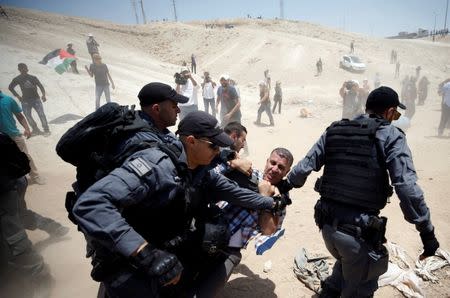 Israeli policemen detain a Palestinian in the Bedouin village of al-Khan al-Ahmar near Jericho in the occupied West Bank July 4, 2018. REUTERS/Mohamad Torokman