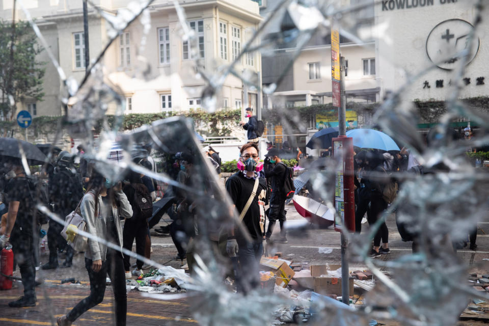 A protester stands in front of a broken pane of glass during a demonstration in Jordan district of Hong Kong, China, on Monday, Nov. 18, 2019. | Kyle Lam/Bloomberg via Getty Images
