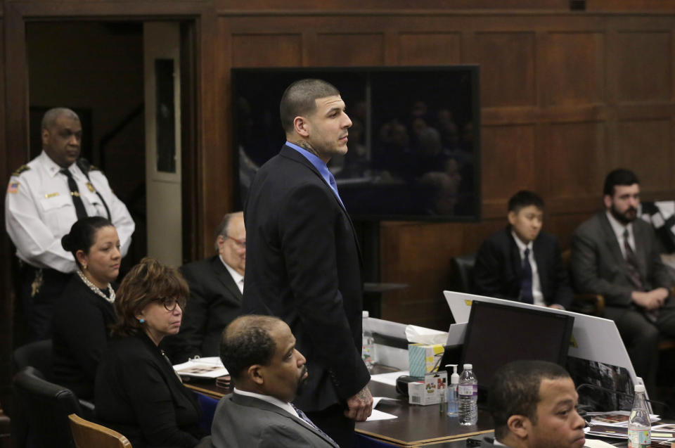 Former New England Patriots tight end Aaron Hernandez, center, stands when asked to do so by defense attorney Jose Baez, not shown, as Baez makes closing arguments in the trial for Hernandez at Suffolk Superior Court, Thursday, April 6, 2017, in Boston. Hernandez is on trial for the July 2012 killings of Daniel de Abreu and Safiro Furtado who he encountered in a Boston nightclub. The former NFL player is already serving a life sentence in the 2013 killing of semi-professional football player Odin Lloyd. (AP Photo/Steven Senne, Pool)