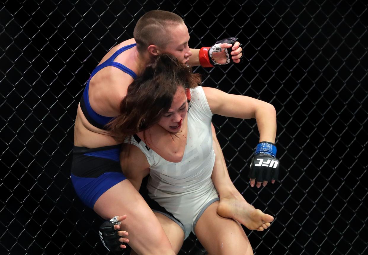 Rose Namajunas, left, takes down Michelle Waterson during their fight in April. (Getty)