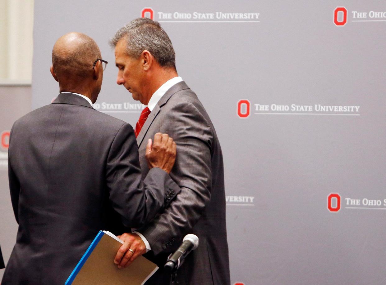 OSU football coach Urban Meyer walks past OSU president Michael Drake after news conference announcing his suspension August 22, 2018. [Eric Albrecht/Dispatch]