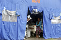 A nurse looks out of a tent where patients were evacuated from a hospital, following an earthquake in Bali, Indonesia, Monday, Aug. 6, 2018. A powerful earthquake struck the Indonesian tourist island of Lombok on Sunday, shaking neighboring Bali, one week after another quake on Lombok killed more than a dozen. (AP Photo/Firdia Lisnawati)