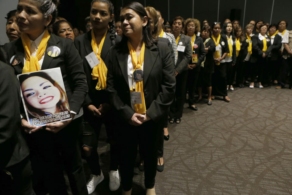 Women with the volunteer group "Colectivo Solecito," or Little Sun Collective, hold photos of their missing relatives during an award ceremony in Mexico City, Tuesday, Oct. 16, 2018. The University of Notre Dame has presented its 2018 Notre Dame Award to the group of Mexican mothers who have led a tireless, years-long search for missing loved ones in the Gulf coast state of Veracruz. (AP Photo/Marco Ugarte)