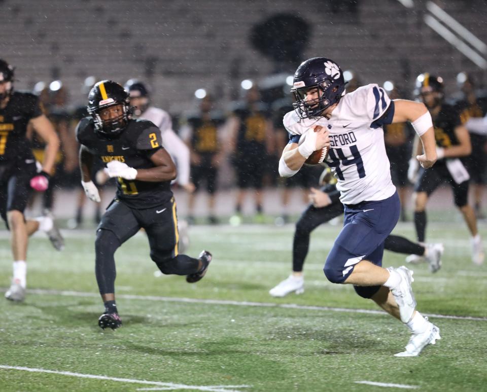 Pittsford's Nathan Rodi intercepts a pass and heads towards the endzone with McQuaid's Gabe Zawolo chasing him during the Section V championship title at SUNY Brockport on Nov. 11, 2022.  Pittsford scored on the next play.