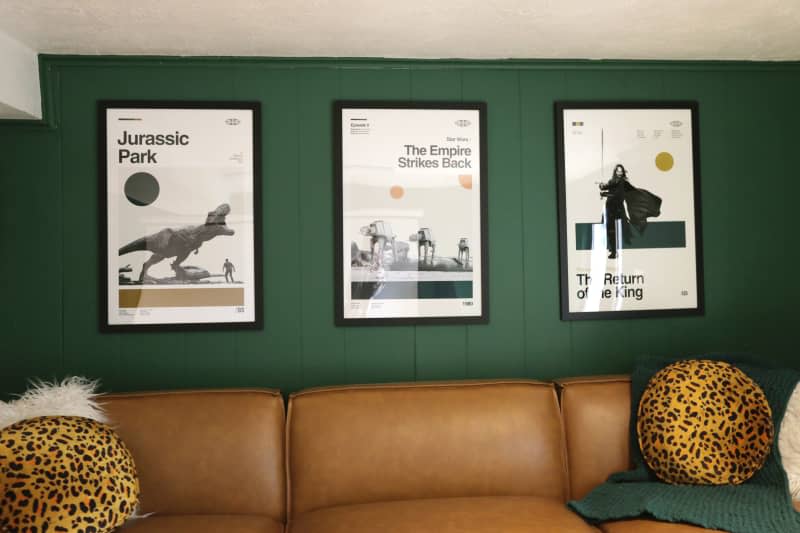 Movie posters mounted on green painted wall in sitting room.