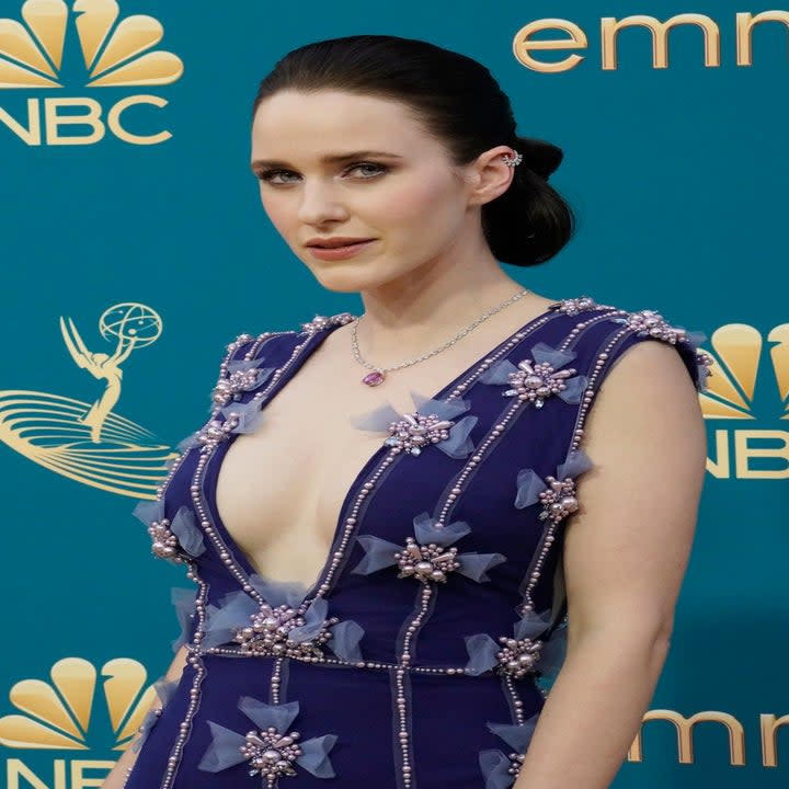 Rachel Brosnahan on the red carpet in a pearl-encrusted dress with a deep v-neck