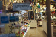 A shop assistant waits for customers at the Murano island in Venice, Italy, Monday, March 2, 2020. Venice in the time of coronavirus is a shell of itself, with empty piazzas, shuttered basilicas and gondoliers idling their days away. (AP Photo/Francisco Seco)