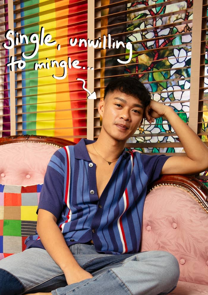 A person sits on a patterned couch with a rainbow flag in the background, wearing a striped shirt. Handwritten text reads, "Single, unwilling to mingle..."