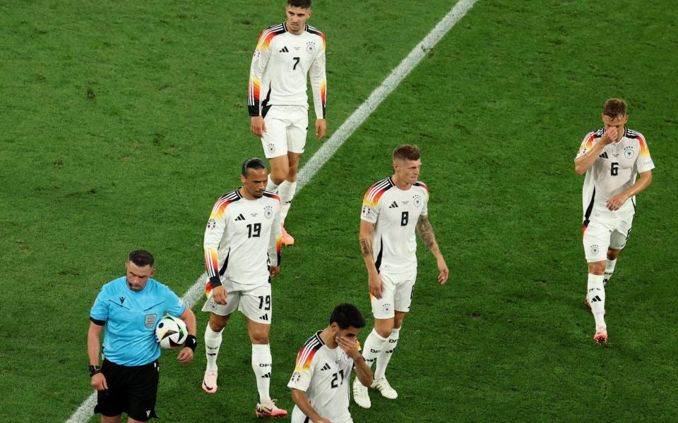 Players of Germany react after the match is interrupted due to thunder and lightning