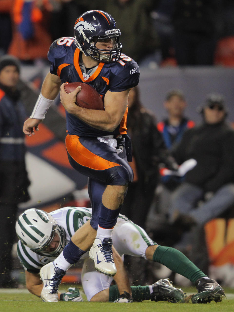 DENVER, CO - NOVEMBER 17: Quarterback Tim Tebow #15 of the Denver Broncos eludes Eric Smith #33 of the New York Jets and rushes 20 yards for the game winning touchdown in the fourth quarter at Sports Authority Field at Mile High on November 17, 2011 in Denver, Colorado. The Broncos defeated the Jets 17-13. (Photo by Doug Pensinger/Getty Images)