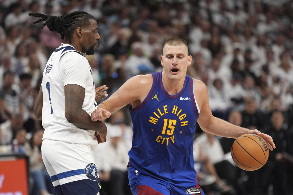 Denver Nuggets center Nikola Jokic (15) works toward the basket as Minnesota Timberwolves center Naz Reid, left, defends during the first half of Game 3 of an NBA basketball second-round playoff series, Friday, May 10, 2024, in Minneapolis. (AP Photo/Abbie Parr)