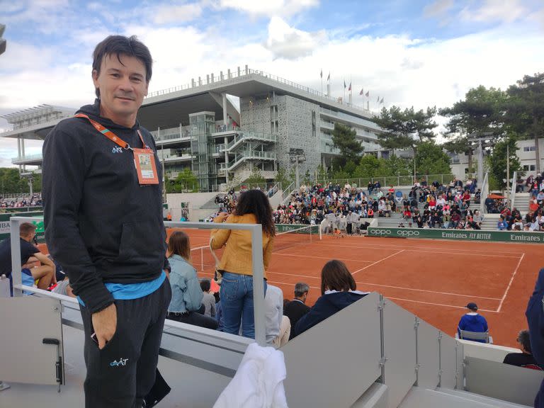Guillermo Coria, en Roland Garros, al lado de la cancha, siguiendo a los jugadores argentinos; al fondo, el emblemático estadio Chatrier, en el que protagonizó una muy particular final con Gastón Gaudio hace 18 años.