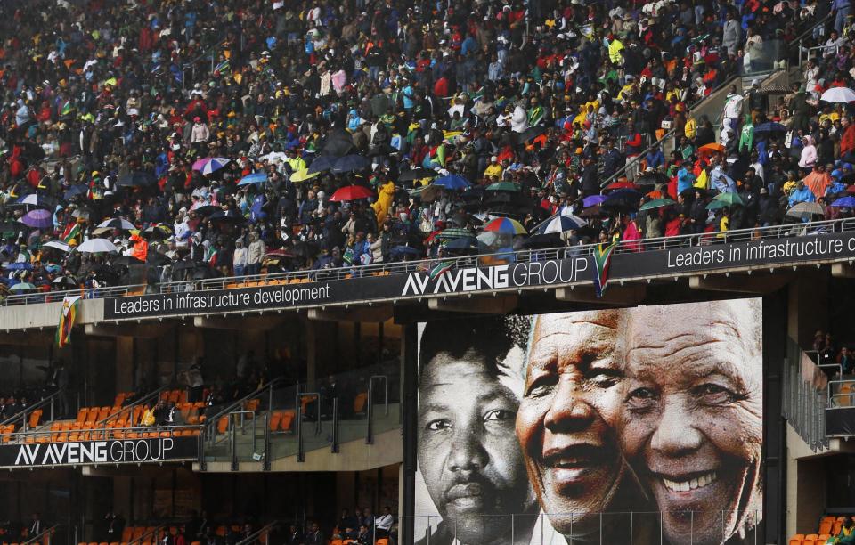 Faces of Nelson Mandela through the ages are shown on a big screen during the memorial service for former South African president Nelson Mandela at the FNB Stadium in Soweto, near Johannesburg, South Africa, Tuesday Dec. 10, 2013. (AP Photo/Ben Curtis)