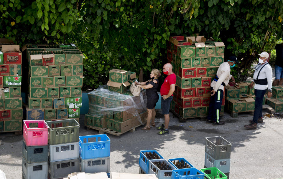 Los compradores esperan ser atendidos por los cargadores para llevar las compras que hicieron en el mercado mayorista Mercabal, el jueves 30 de julio de 2020, en La Habana, Cuba. El gobierno está permitiendo que las empresas privadas compren al por mayor por primera vez. (AP Foto/Ismael Francisco)