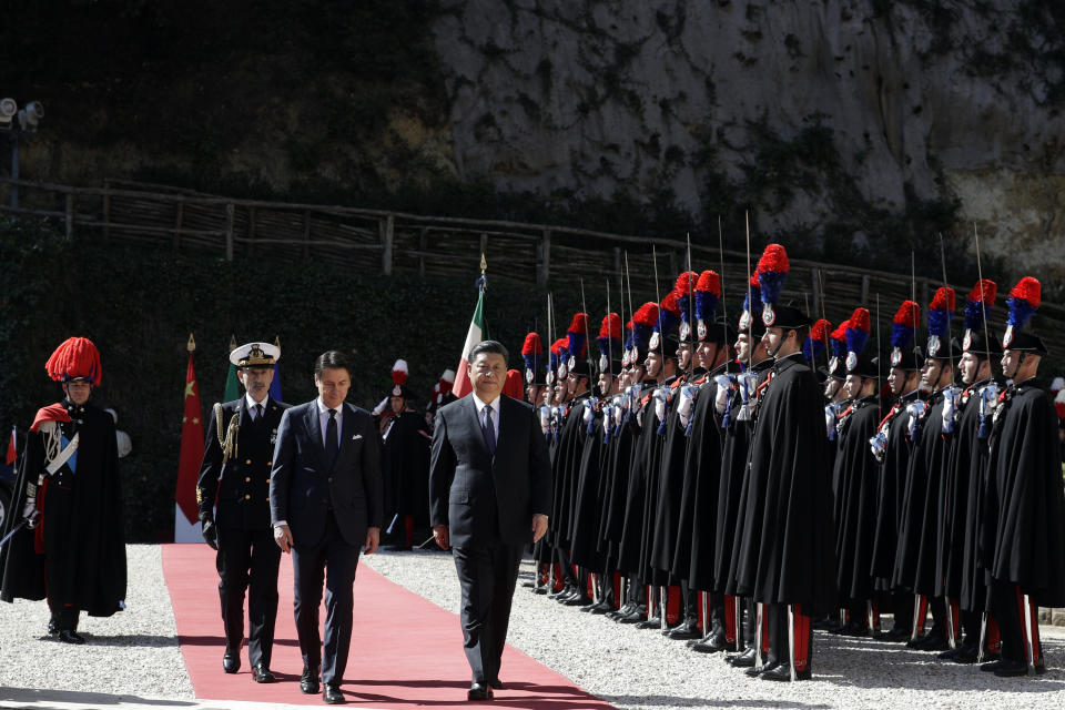 Chinese President Xi Jinping, right, and Italian Premier Giuseppe Conte walk past the honor guard during their meeting at Rome's Villa Madama, Saturday, March 23, 2019. (AP Photo/Andrew Medichini)