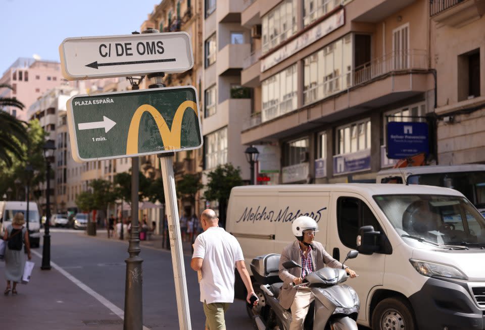 A sign points the direction to a McDonald's Corp. restaurant in Palma de Mallorca, Spain