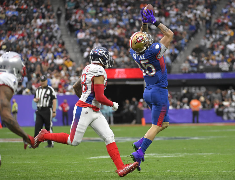 FILE - NFC tight end George Kittle, right, of the San Francisco 49ers, catches a pass in front of AFC outside linebacker Harold Landry, left, of the Tennessee Titans, during the first half of the Pro Bowl NFL football game, Sunday, Feb. 6, 2022, in Las Vegas. The NFL is replacing the Pro Bowl with weeklong skills competitions and a flag football game. The new event will be renamed “The Pro Bowl Games” and will feature AFC and NFC players showcasing their football and non-football skills in challenges over several days. (AP Photo/David Becker, File)